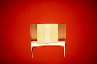 Modern minimalist office desk with red, white, and yellow accents and a laptop open to a contact form