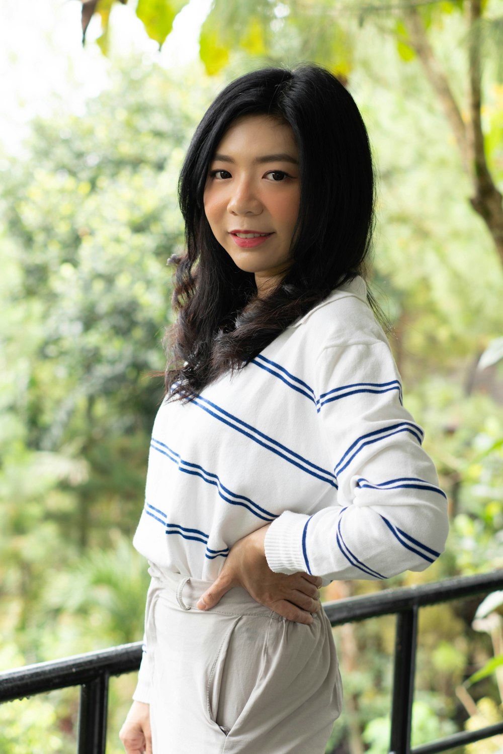 a woman in a white and blue striped sweater posing for a picture