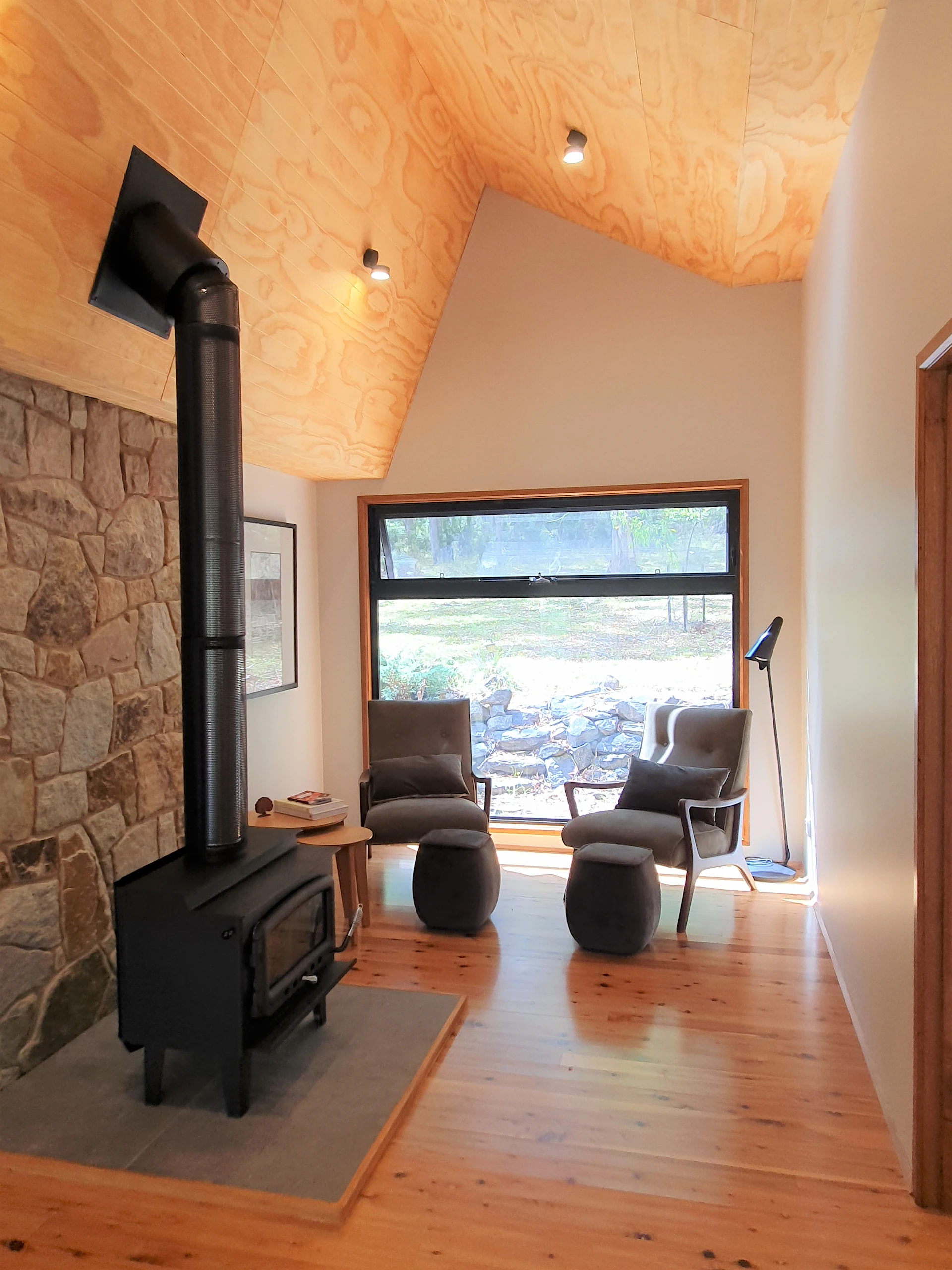 Cozy interior corner of the medieval gîte with exposed wooden beams and a warm fireplace inviting relaxation.