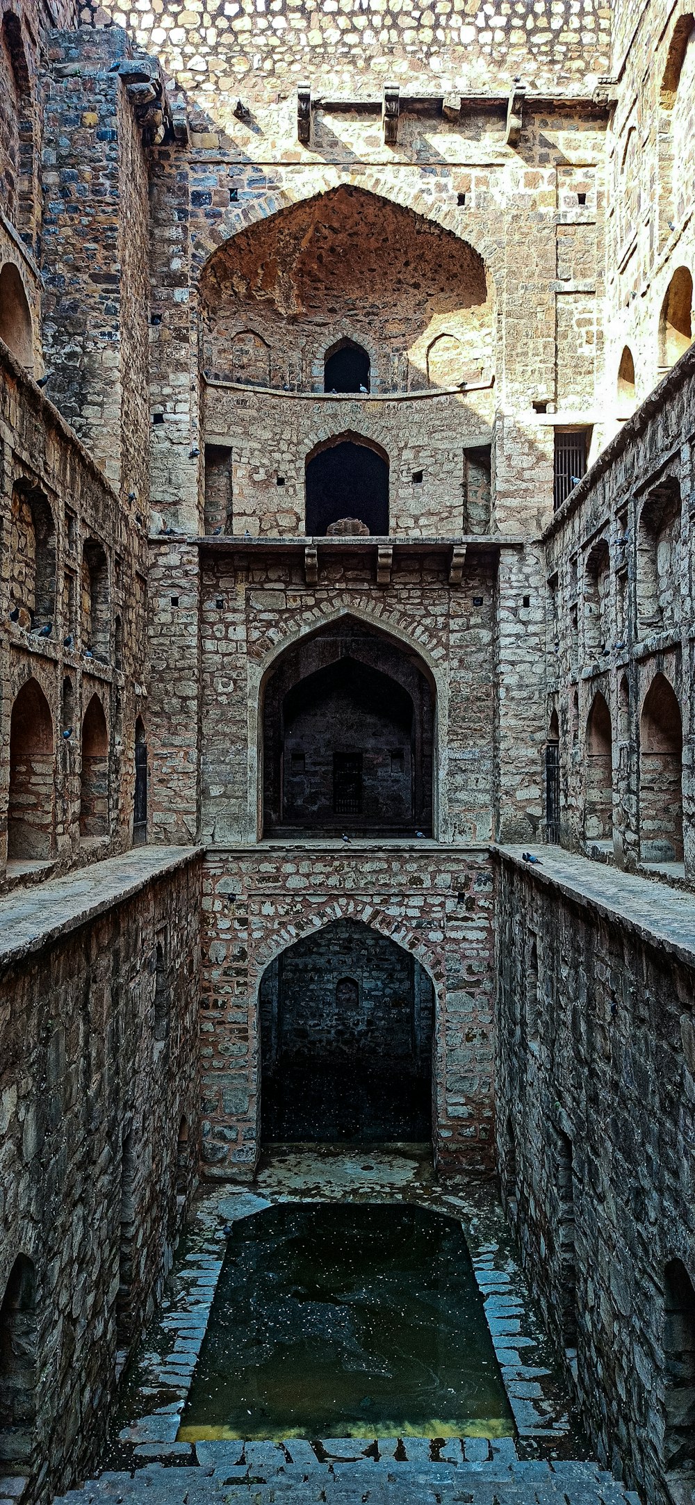 a stone building with a pool in the middle of it