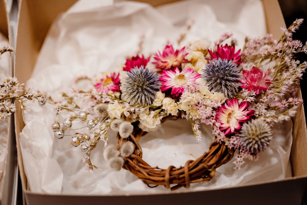 a box with a wreath and flowers inside of it