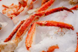 Crab clusters freshly caught with seaweed around, displayed on ice.