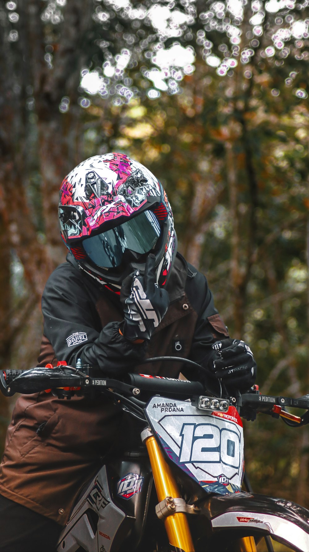 a person wearing a helmet sitting on a dirt bike