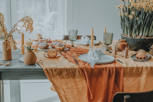 a table set with plates, cups, and vases