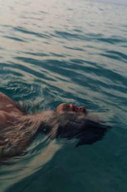 a man swimming in the ocean with his head above the water