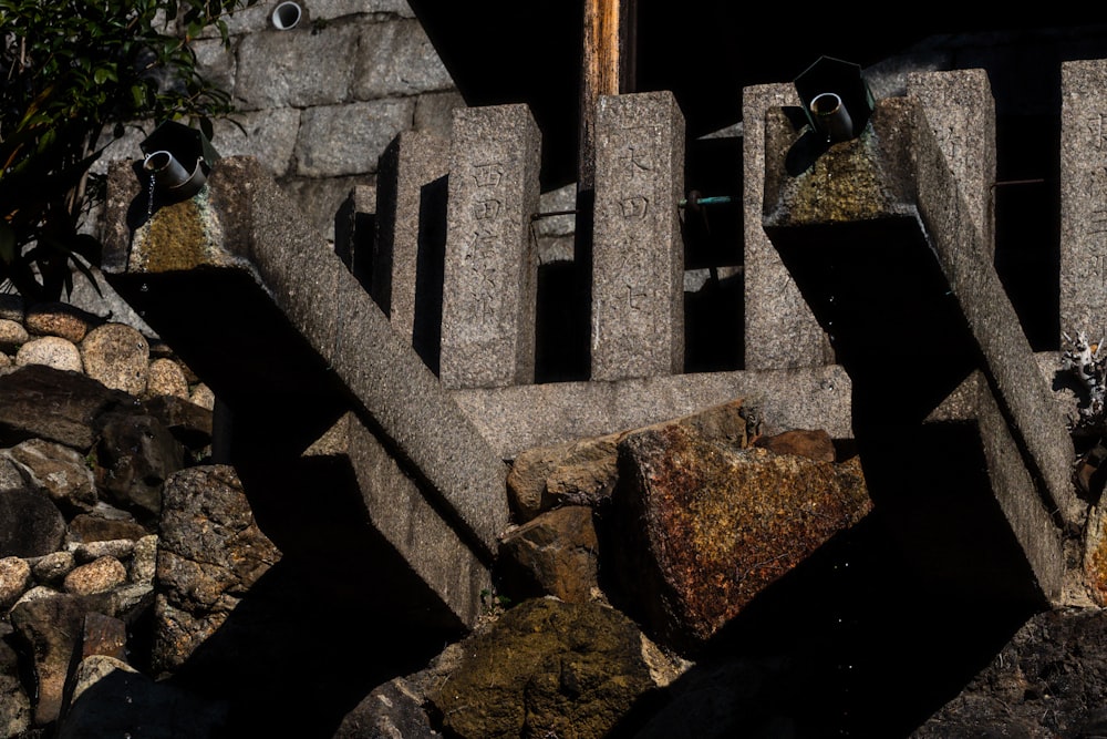 a bird sitting on top of a stone fence