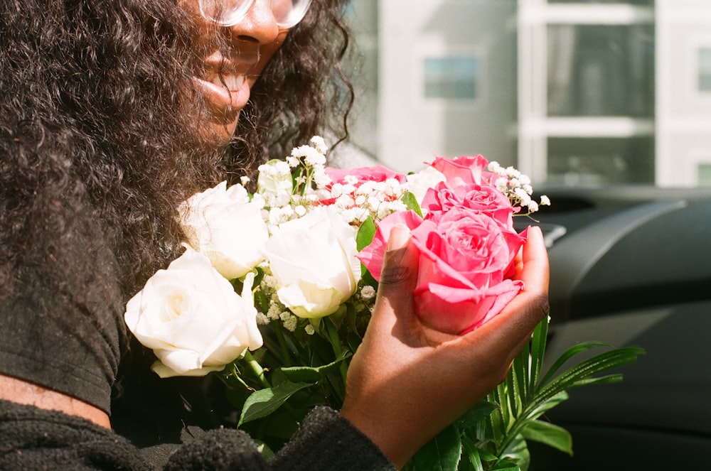 a woman holding a bouquet of flowers in her hands