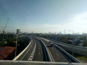 A close-up view of a team repairing a busy highway under clear skies.