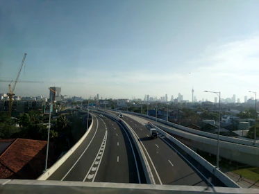 A close-up view of a team repairing a busy highway under clear skies.