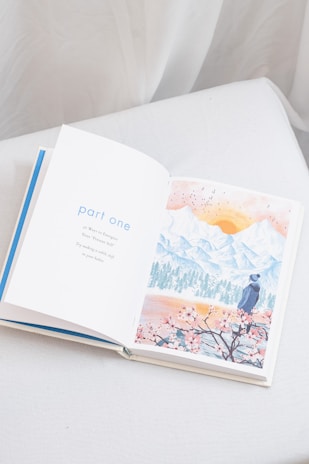 an open book sitting on top of a white couch