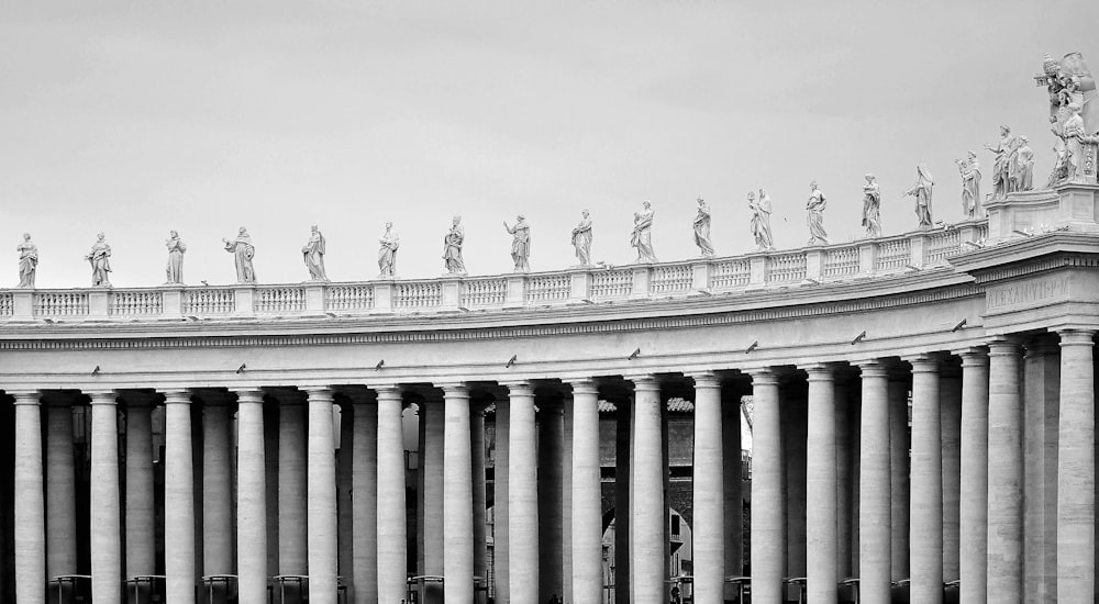 a black and white photo of a building with statues on top of it