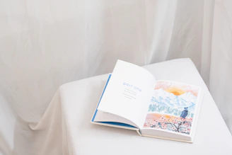 an open book sitting on top of a white table
