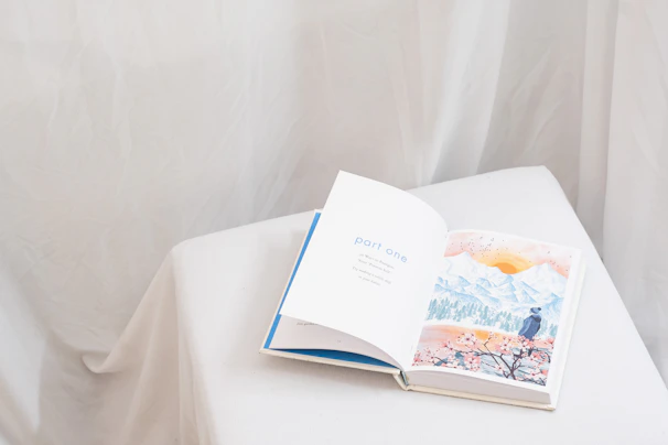 an open book sitting on top of a white table