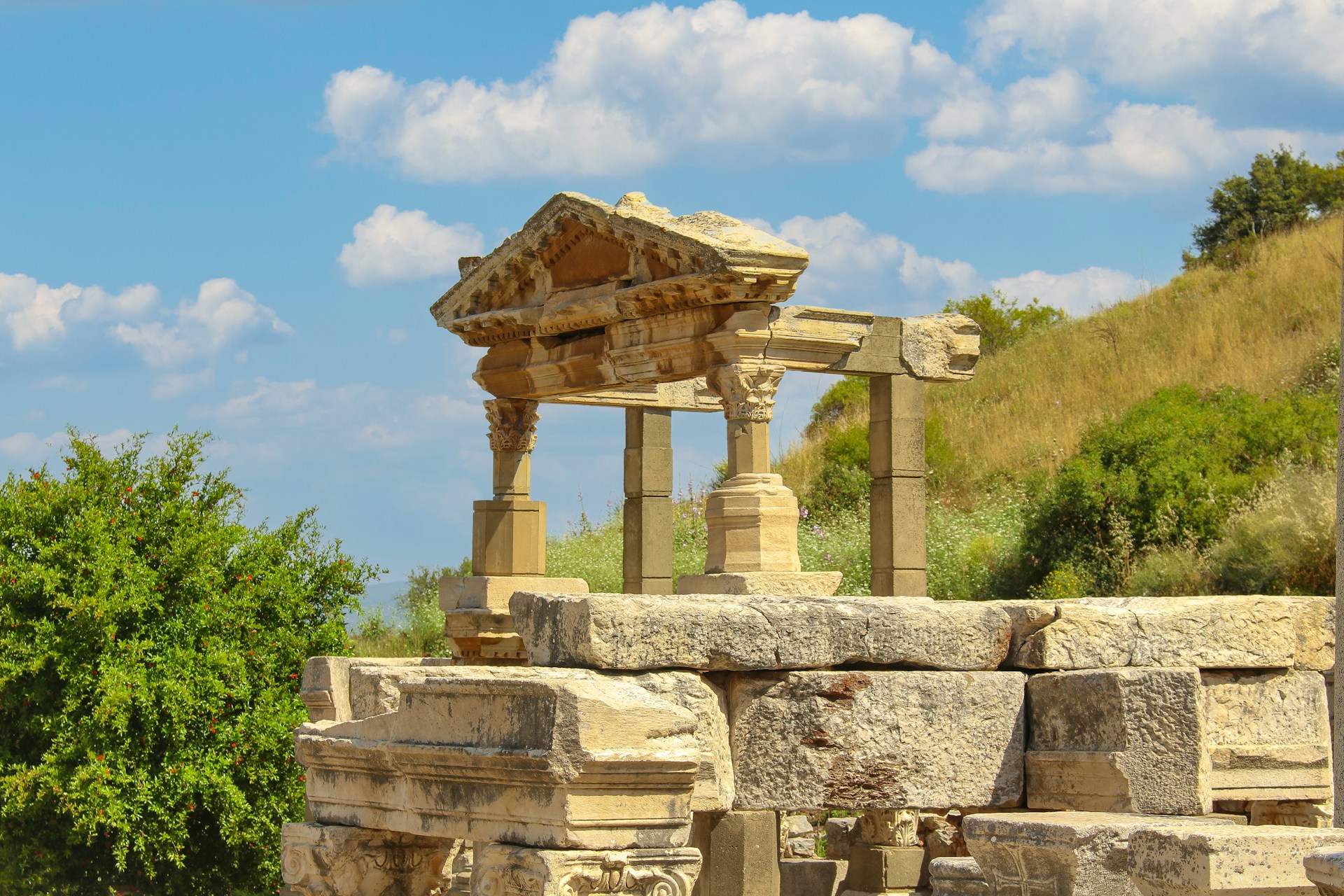 a stone structure sitting on top of a lush green hillside
