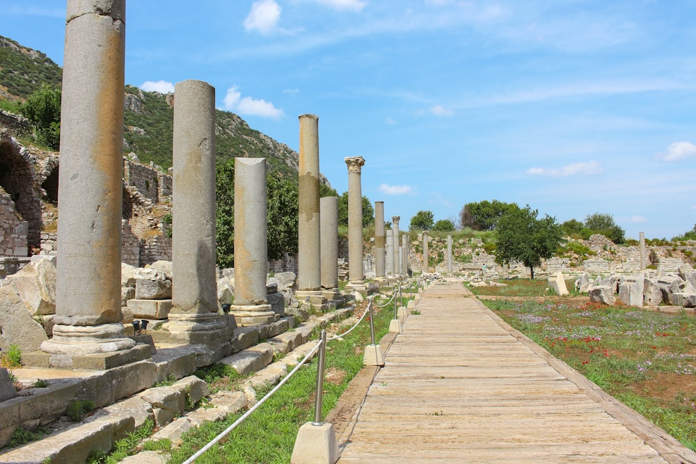 a long walkway between two large stone pillars