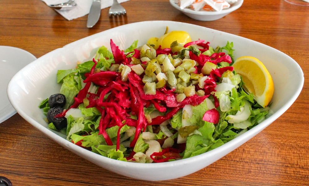 a bowl of salad on a wooden table