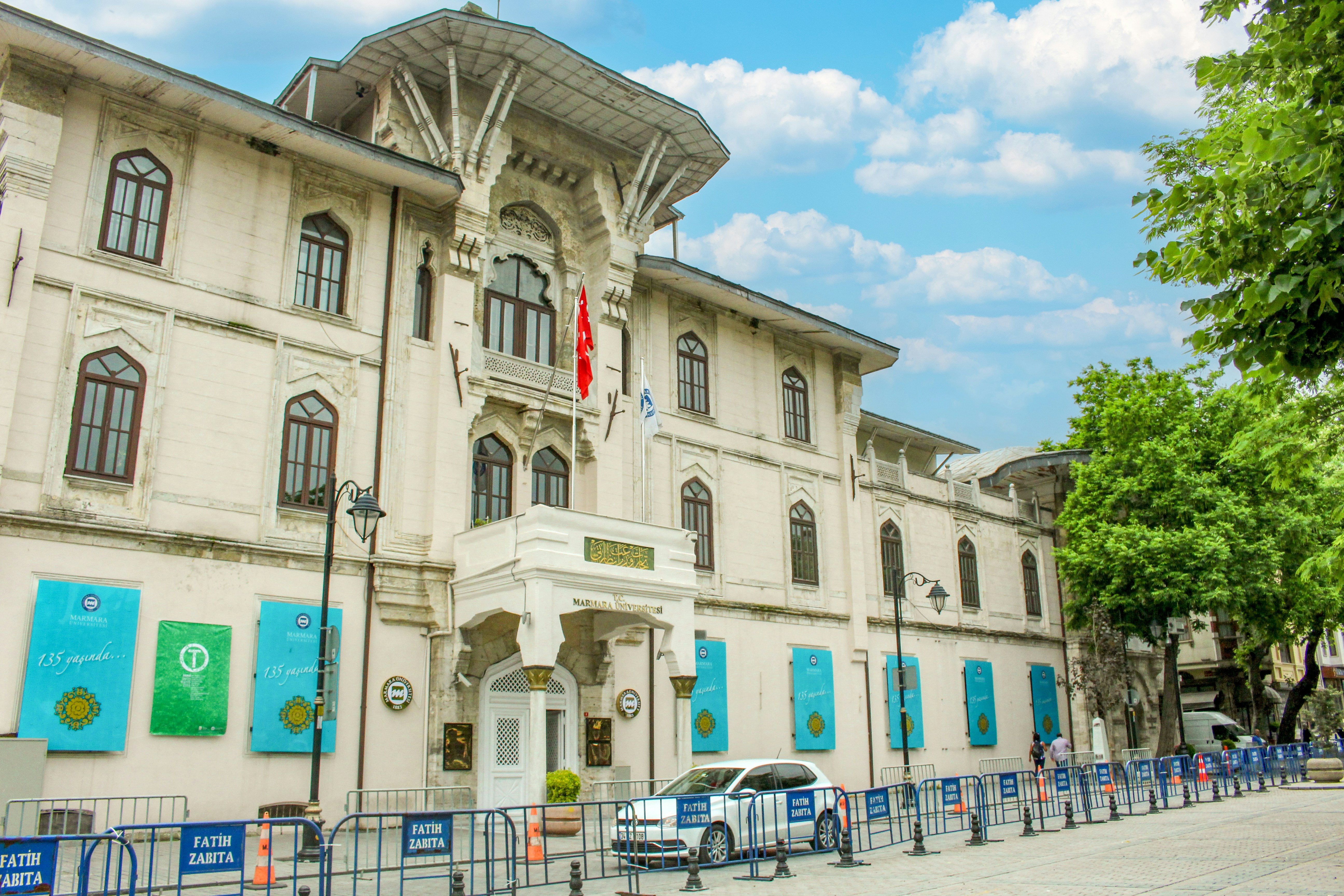 a large white building with many windows and a car parked in front of it