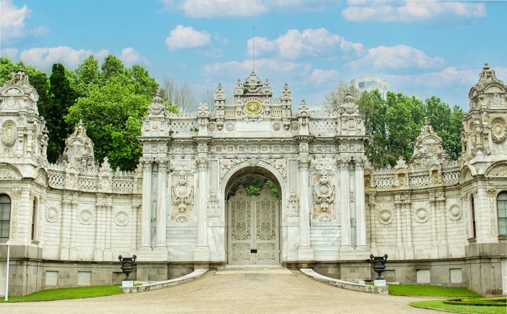 a large white gate with a clock on top of it