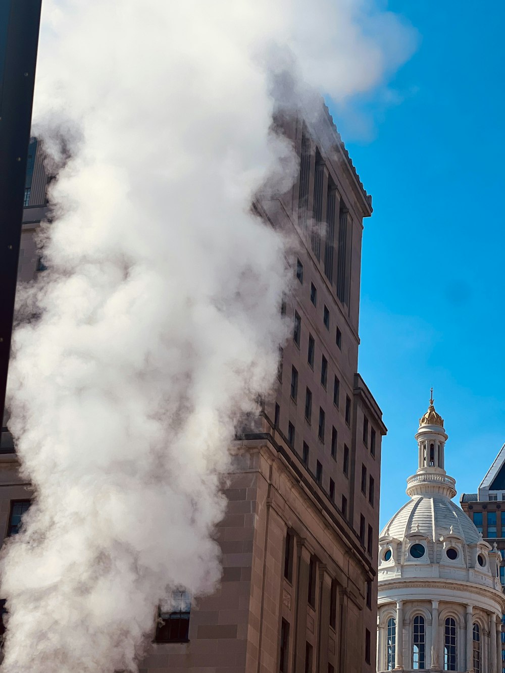 a building with a clock tower and steam coming out of it