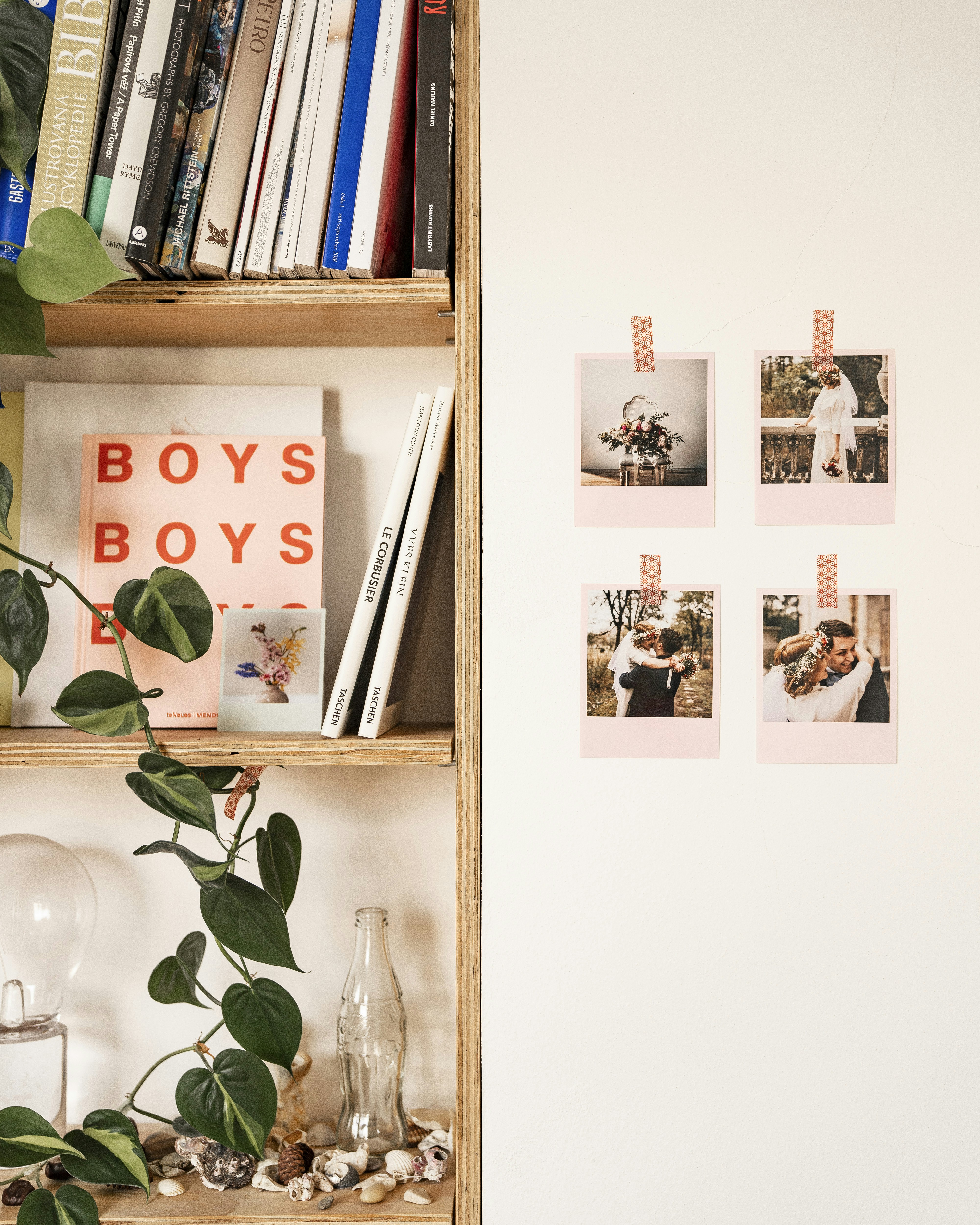 a bookshelf filled with lots of books next to a white wall