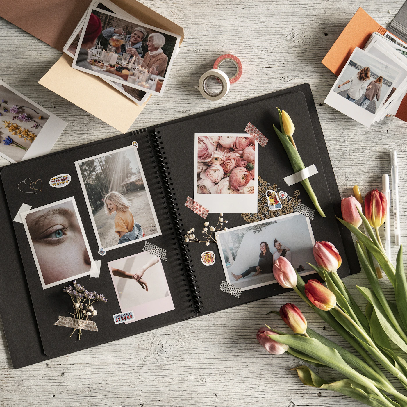 Open scrapbook with printed photographs and flowers as a first anniversary gift