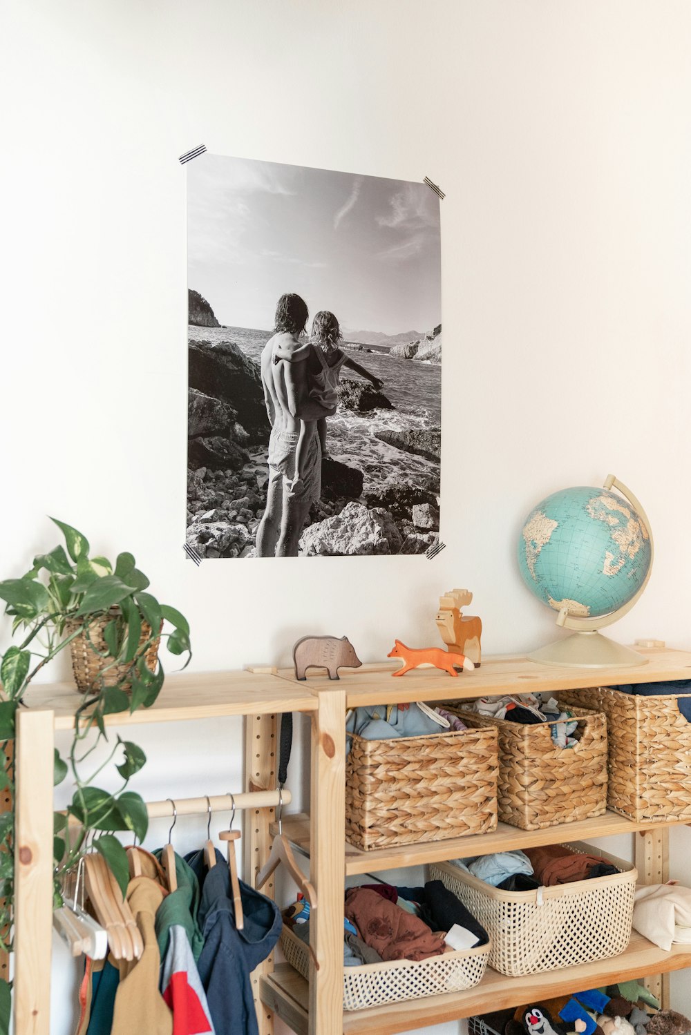 a black and white photo of two children standing on a shelf