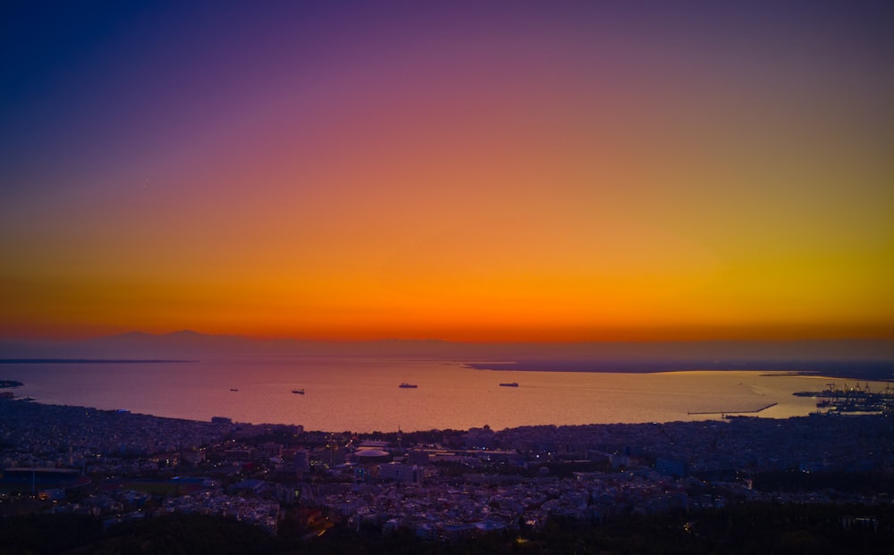 a sunset over a city and a body of water