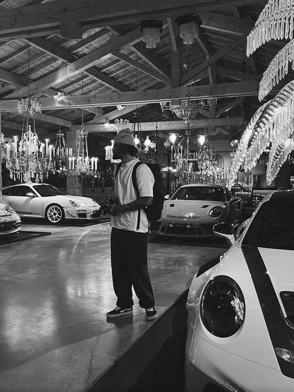 a man standing in a parking garage next to a bunch of cars