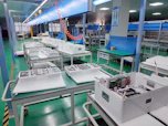 A warm-lit factory floor where skilled workers assemble sleek LED lighting products.