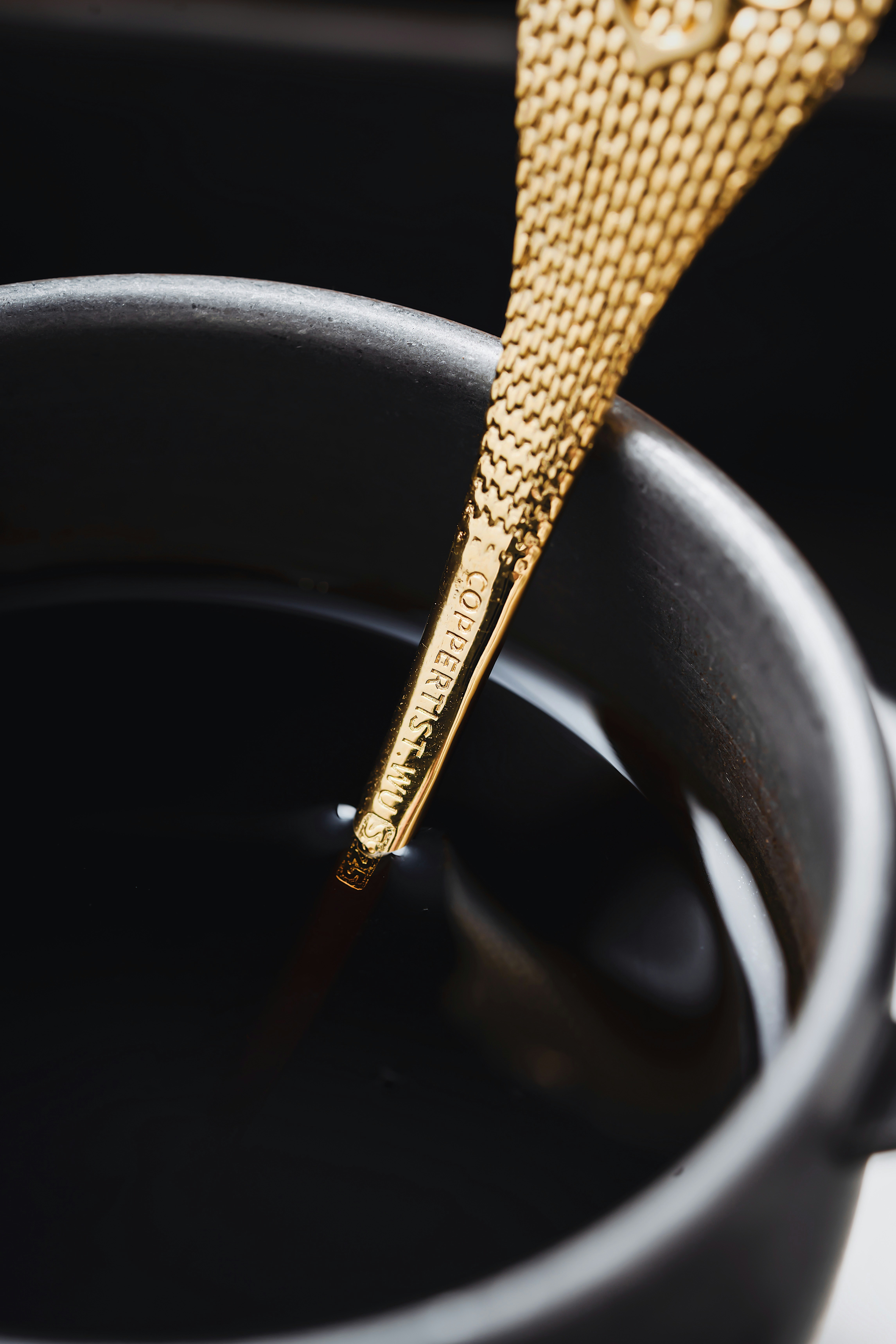A golden object is sticking out of a black pot photo – Free Cup Image ...