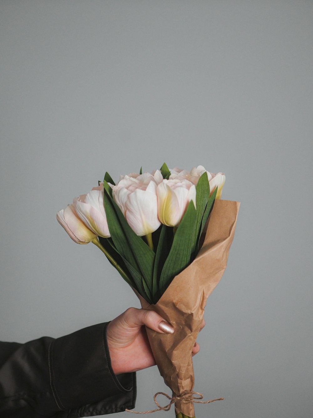 a person holding a bouquet of white tulips