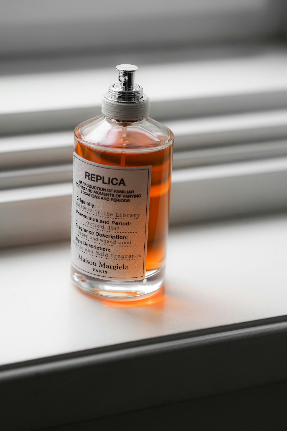 a bottle of perfume sitting on a window sill