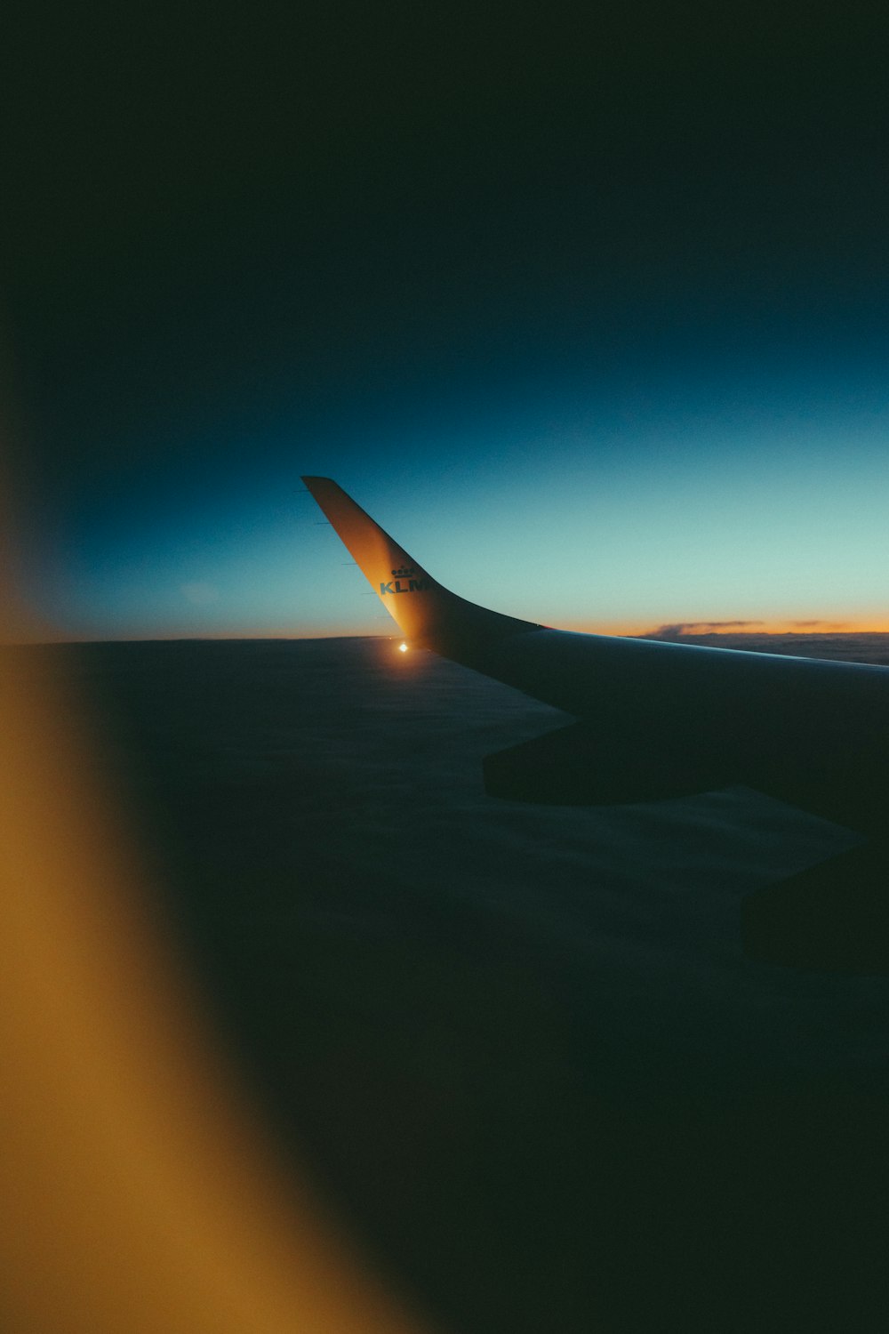 a view of the wing of an airplane at dusk