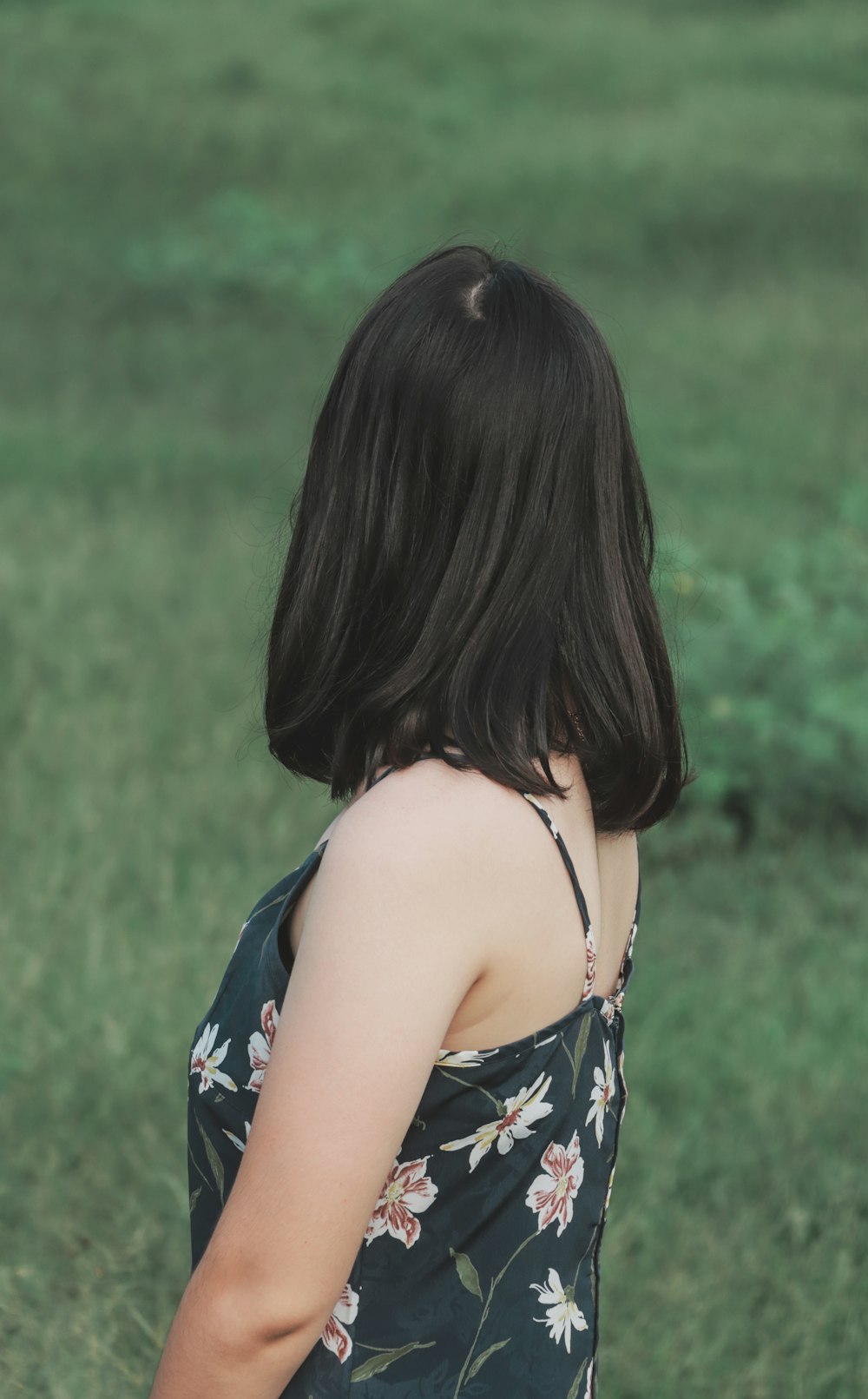 a woman standing in a field with a frisbee in her hand