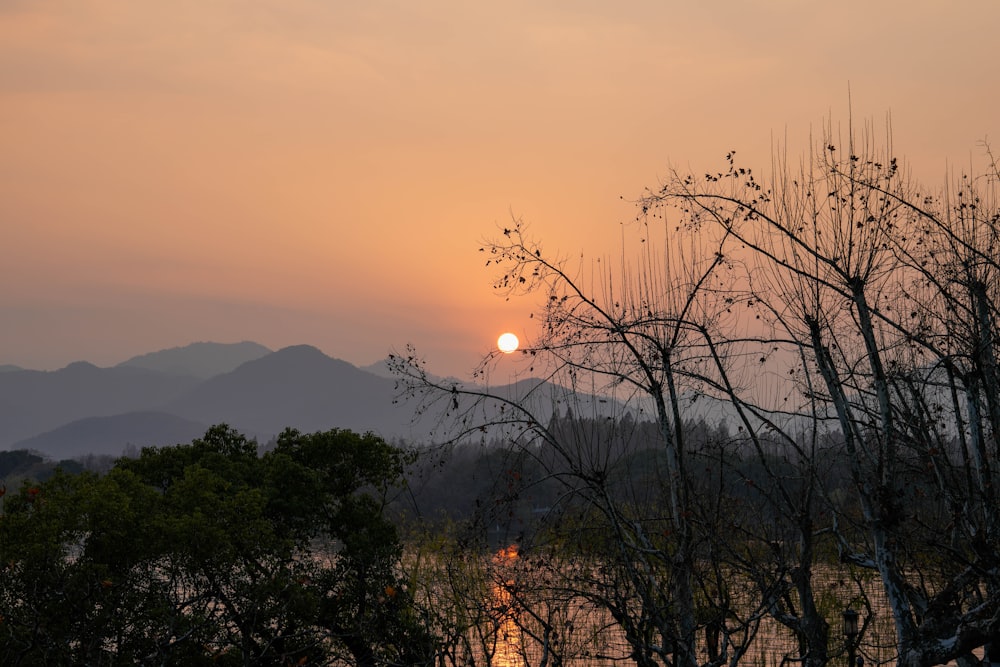 the sun is setting over the mountains in the distance