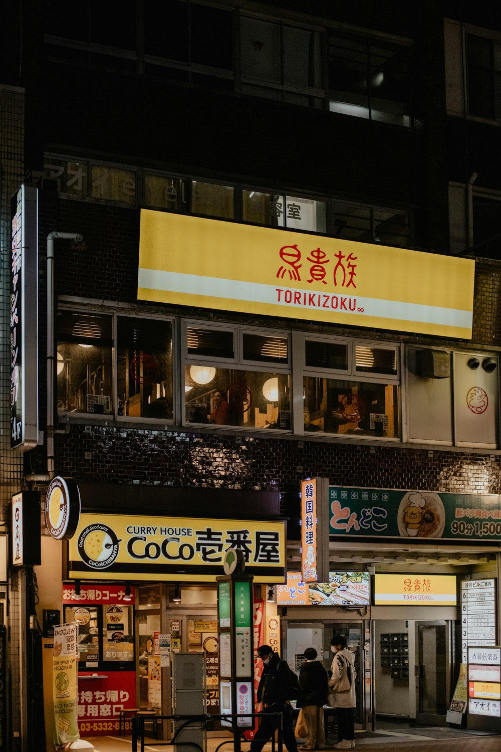 a couple of people walking down a street at night