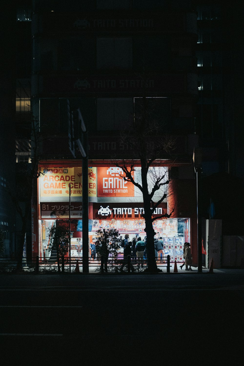 a dark city street at night with a store front lit up