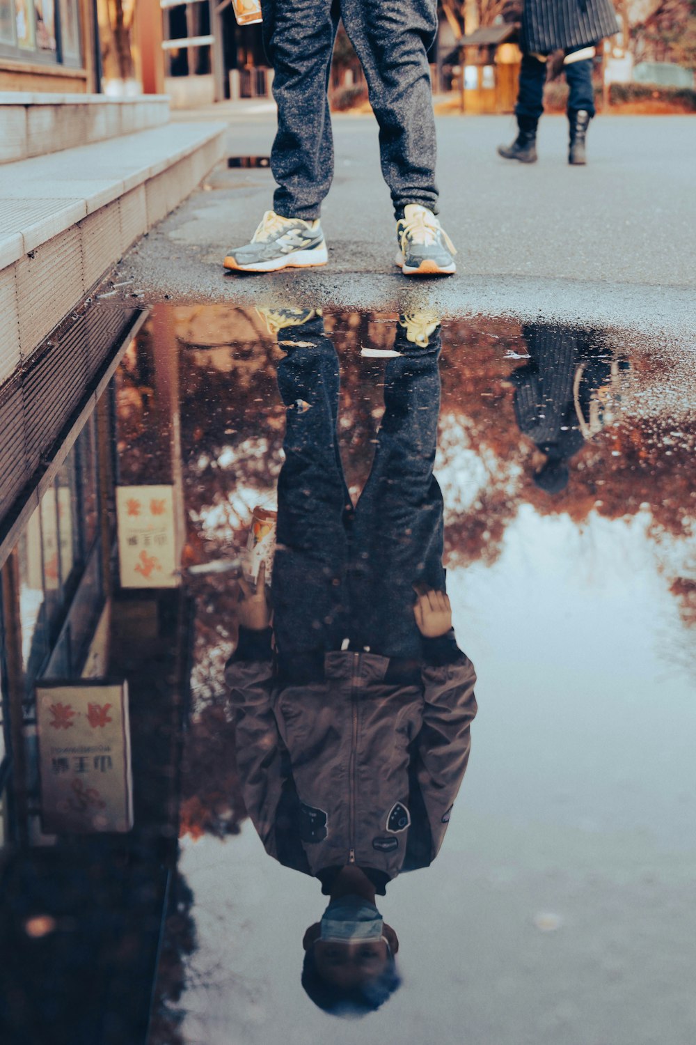 a reflection of a person standing in a puddle