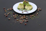 Rows of rich pistachio brownies with a smooth, creamy topping and sprinkled pistachio crumbs.