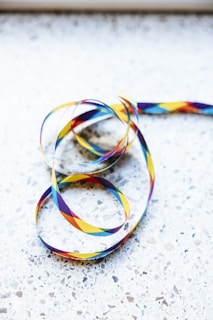 a multicolored ribbon on a white surface