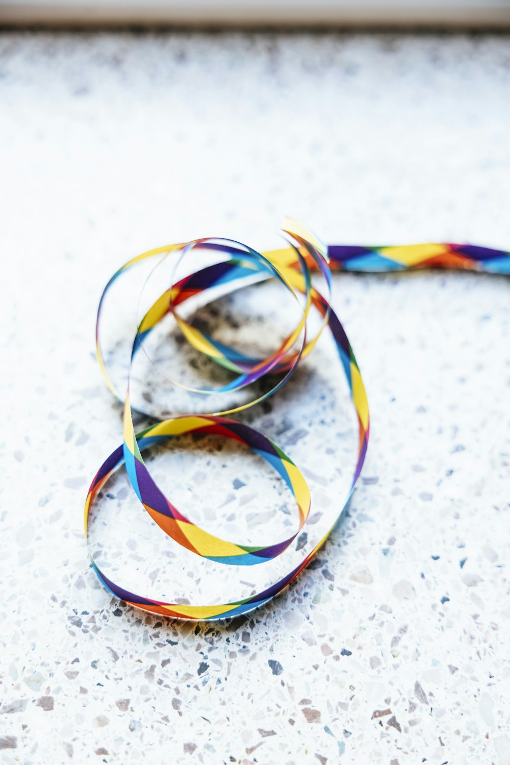 a multicolored ribbon on a white surface