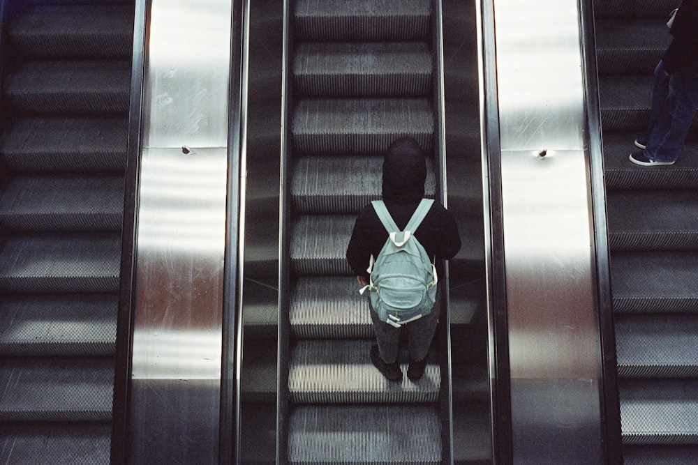 uma pessoa em uma escada rolante com uma mochila