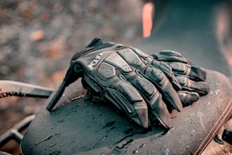 a pair of gloves sitting on top of a motorcycle
