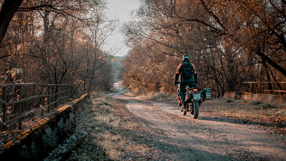 a man riding a bike down a dirt road
