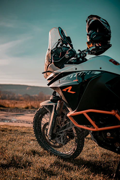 a motorcycle parked in a field on a sunny day