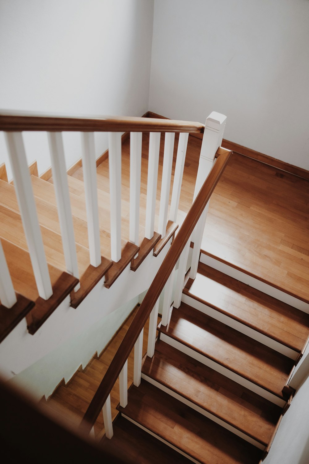 a wooden staircase with white railing and handrail