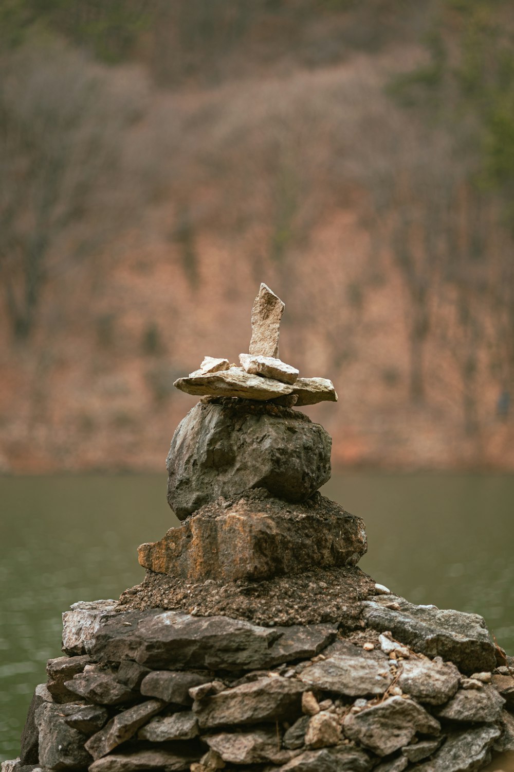 a pile of rocks sitting next to a body of water
