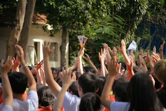 a group of people holding up their hands in the air