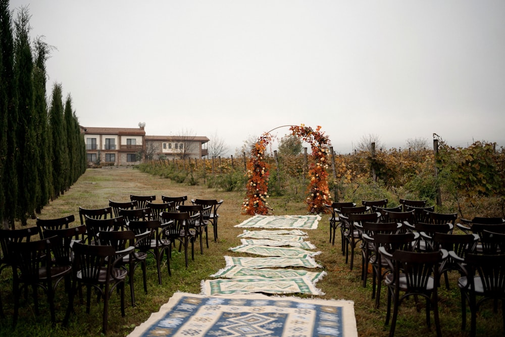 an outdoor ceremony set up with chairs and rugs