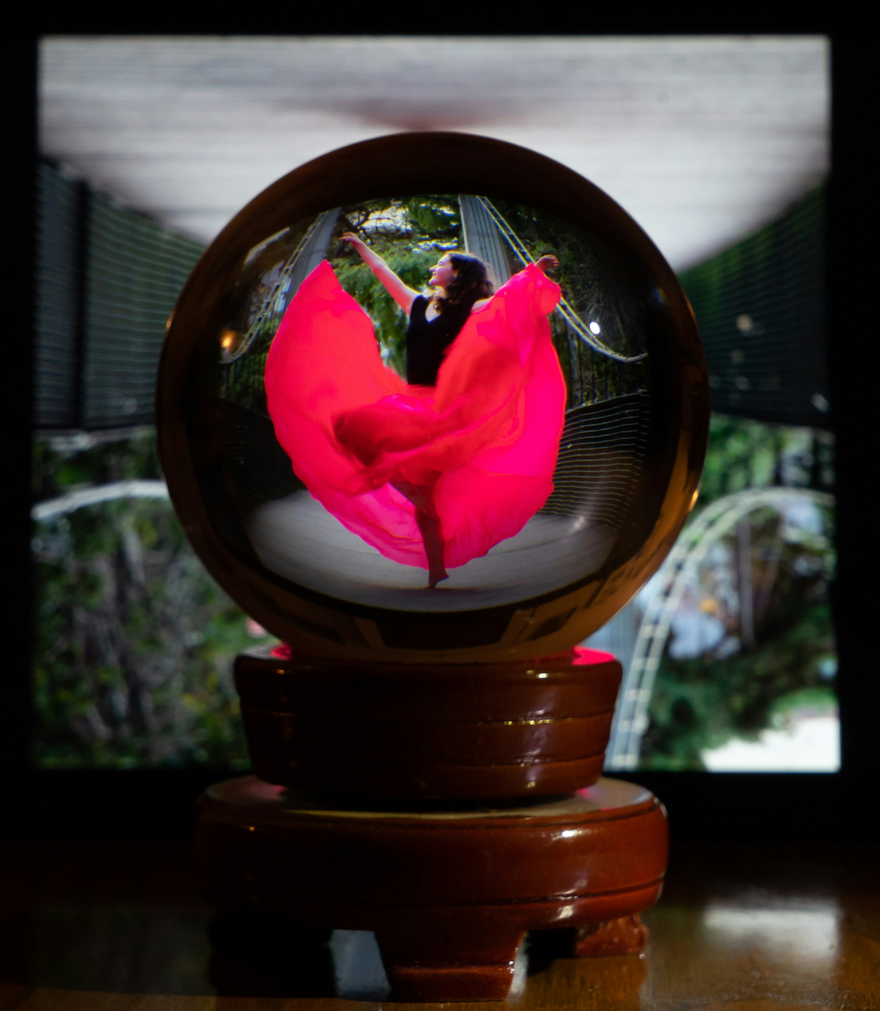 Une femme en robe rouge danse dans une boule de verre